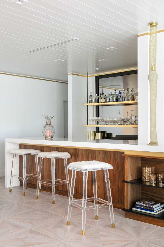 Ispirazione per un bancone bar contemporaneo di medie dimensioni con ante in legno scuro, paraspruzzi a specchio, pavimento beige e top bianco
