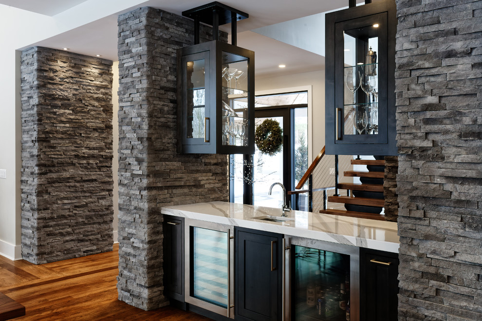 Inspiration for a contemporary wet bar in Cincinnati with a submerged sink, shaker cabinets, dark wood cabinets, quartz worktops, medium hardwood flooring, brown floors and white worktops.