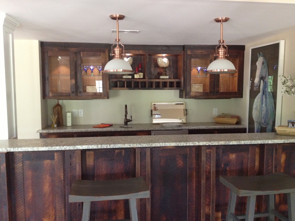 Foto di un bancone bar classico di medie dimensioni con lavello sottopiano, ante di vetro, top in granito, ante in legno bruno e moquette