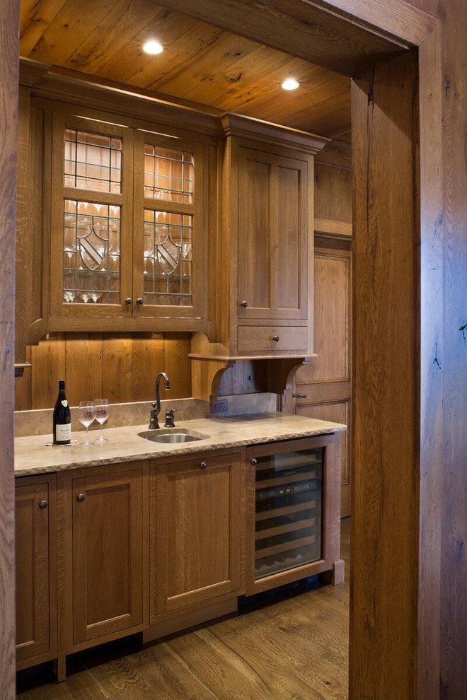 Example of a mid-sized mountain style single-wall medium tone wood floor and brown floor wet bar design in Charlotte with an undermount sink, shaker cabinets, medium tone wood cabinets, brown backsplash and wood backsplash