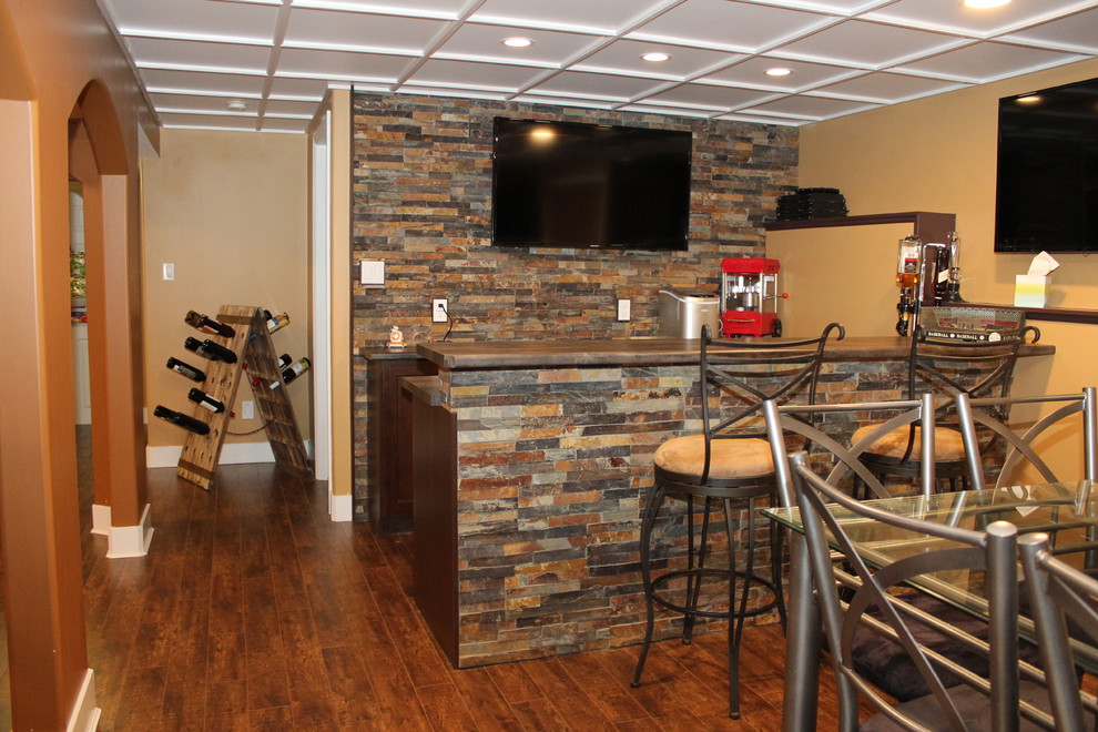 Medium sized rustic galley breakfast bar in Edmonton with no sink, shaker cabinets, dark wood cabinets, laminate countertops, multi-coloured splashback, medium hardwood flooring and slate splashback.