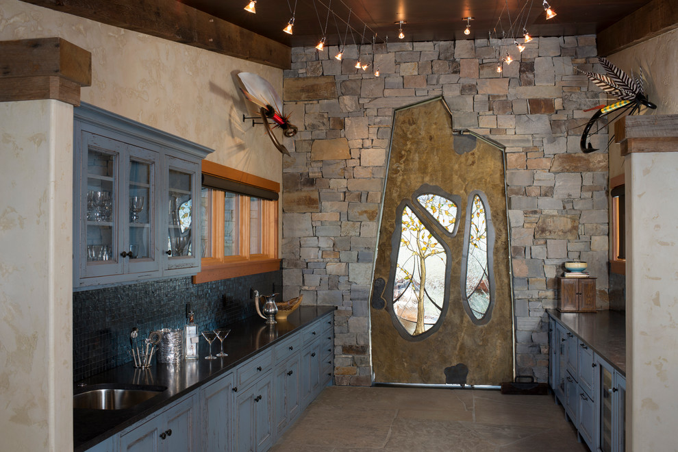 Zweizeilige Rustikale Hausbar mit Bartresen, Unterbauwaschbecken, blauen Schränken und Küchenrückwand in Schwarz in Sonstige