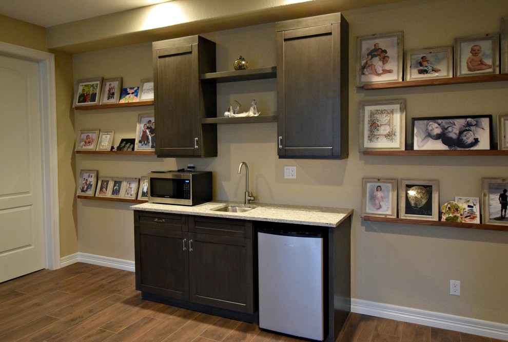 Photo of a small traditional single-wall wet bar in Denver with a submerged sink, recessed-panel cabinets and dark wood cabinets.