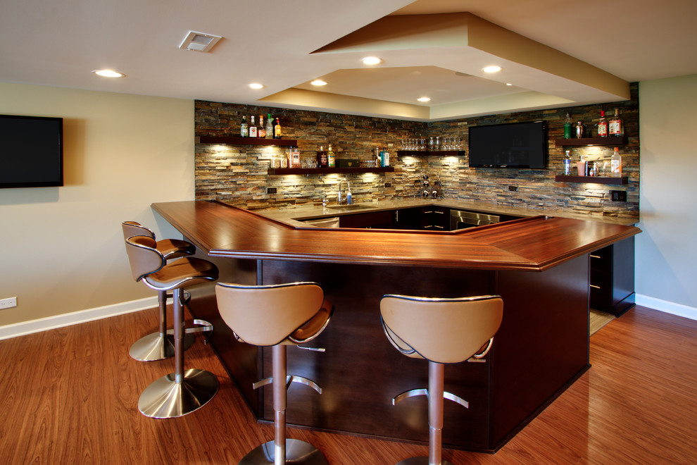 Idee per un grande bancone bar contemporaneo con ante in legno bruno, top in legno, paraspruzzi multicolore, paraspruzzi con piastrelle in pietra, pavimento in legno massello medio e top marrone