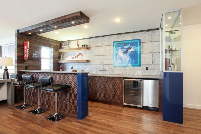 Mid-sized trendy u-shaped dark wood floor seated home bar photo in Calgary with an undermount sink, flat-panel cabinets, brown cabinets and solid surface countertops
