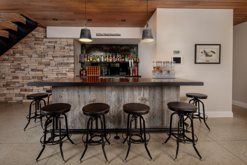 Ejemplo de bar en casa con barra de bar lineal urbano de tamaño medio con armarios abiertos, puertas de armario con efecto envejecido, encimera de madera, salpicadero negro, suelo beige y encimeras marrones