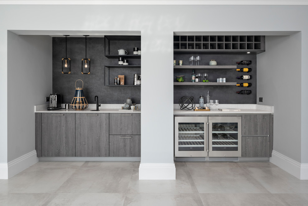 Foto de bar en casa con fregadero lineal contemporáneo grande con armarios con paneles lisos, suelo gris y encimeras blancas