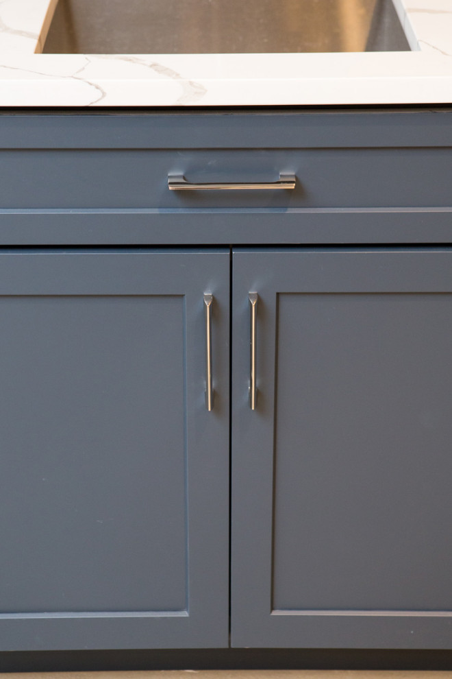 Exempel på en mellanstor klassisk flerfärgade linjär flerfärgat hemmabar med vask, med en undermonterad diskho, skåp i shakerstil, blå skåp, bänkskiva i kvartsit, brunt stänkskydd, stänkskydd i trä, betonggolv och grått golv