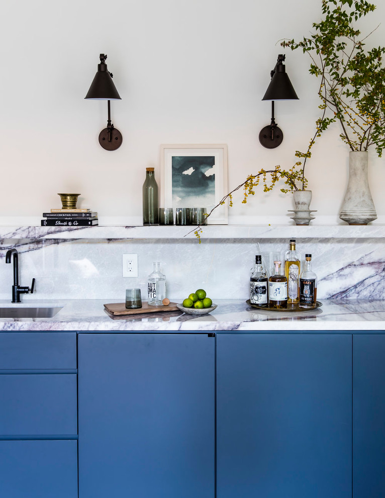 Ispirazione per un angolo bar con lavandino design con lavello sottopiano, ante lisce, ante blu, paraspruzzi bianco e top bianco