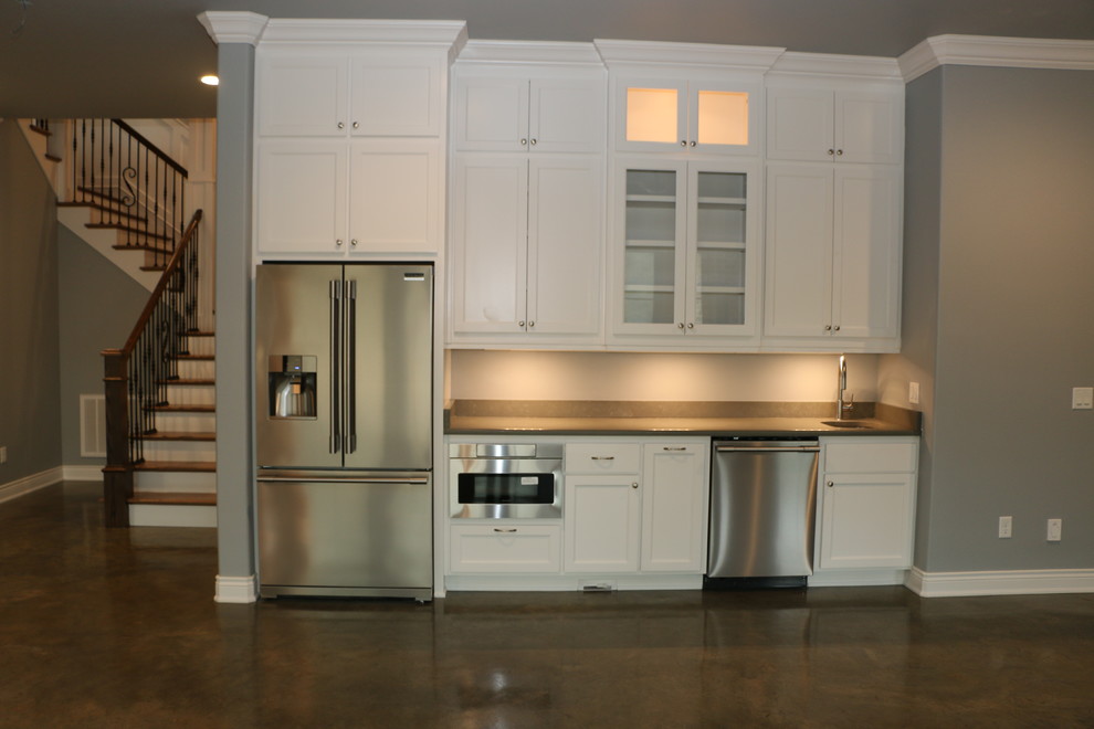 Exempel på en lantlig grå linjär grått hemmabar med vask, med en undermonterad diskho, skåp i shakerstil, vita skåp, bänkskiva i kvarts, betonggolv och brunt golv