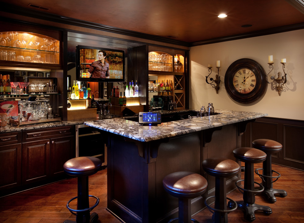 Foto di un bancone bar chic con parquet scuro, ante con bugna sagomata, ante in legno bruno, pavimento marrone e top multicolore