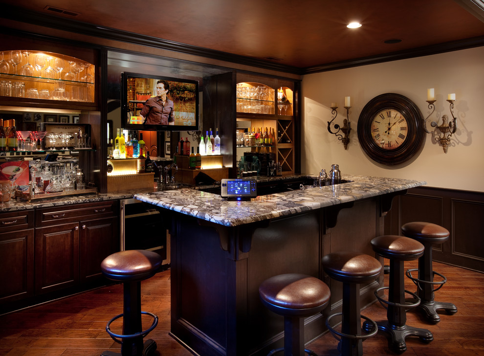 Inspiration for a timeless galley dark wood floor and brown floor seated home bar remodel in Columbus with raised-panel cabinets, dark wood cabinets and multicolored countertops