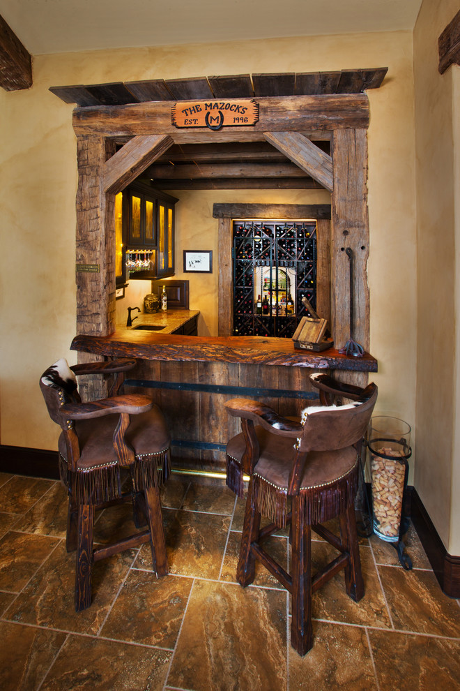 Idée de décoration pour un bar de salon méditerranéen en L avec des tabourets, un plan de travail en bois et un sol marron.