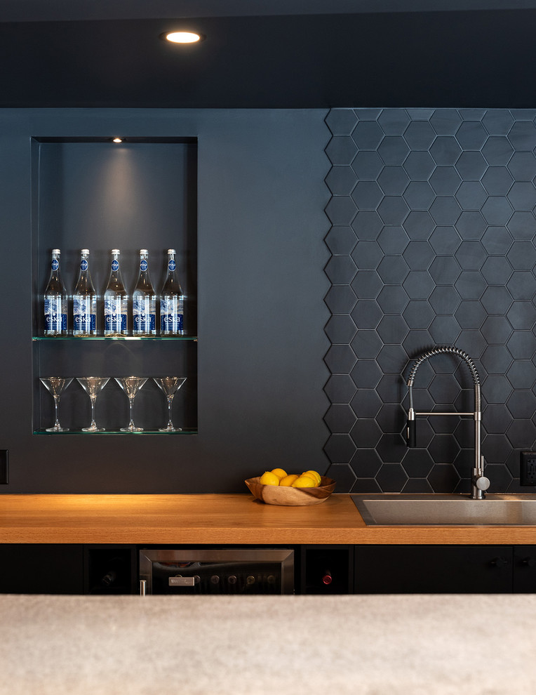 Photo of a contemporary single-wall wet bar in Toronto with a built-in sink, flat-panel cabinets, black cabinets, wood worktops, black splashback and brown worktops.