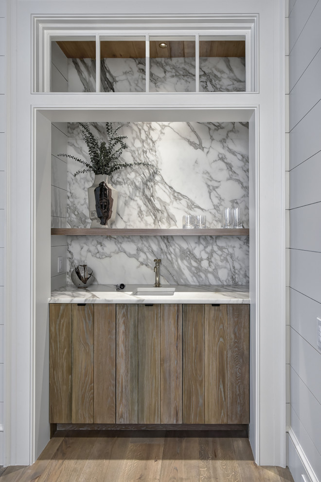 Foto på en mellanstor lantlig vita linjär hemmabar med vask, med en undermonterad diskho, släta luckor, skåp i mellenmörkt trä, marmorbänkskiva, flerfärgad stänkskydd, stänkskydd i sten, mellanmörkt trägolv och brunt golv