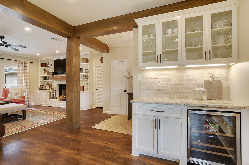 Inspiration for a medium sized rural single-wall wet bar in New Orleans with shaker cabinets, white cabinets, granite worktops, travertine splashback, brown floors, beige worktops, no sink, beige splashback and dark hardwood flooring.