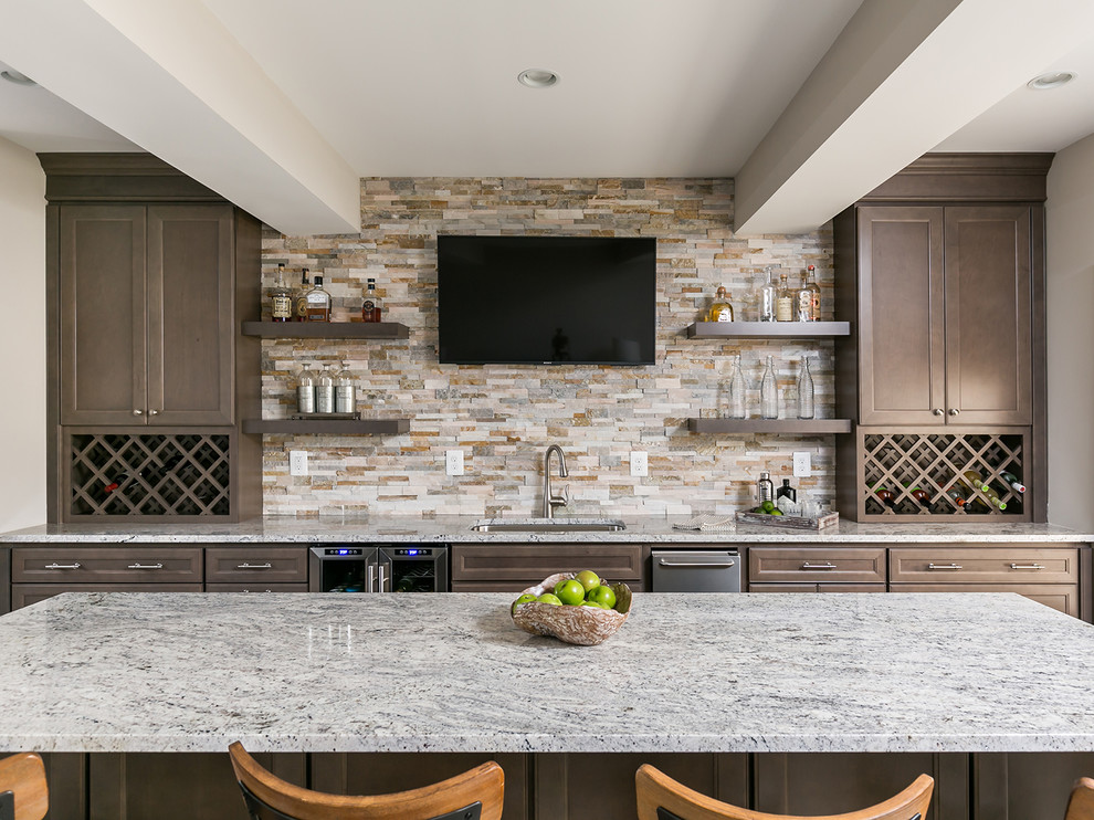 This is an example of a large classic single-wall breakfast bar in DC Metro with recessed-panel cabinets, brown cabinets, granite worktops, beige splashback, stone tiled splashback, laminate floors, brown floors, a submerged sink and grey worktops.