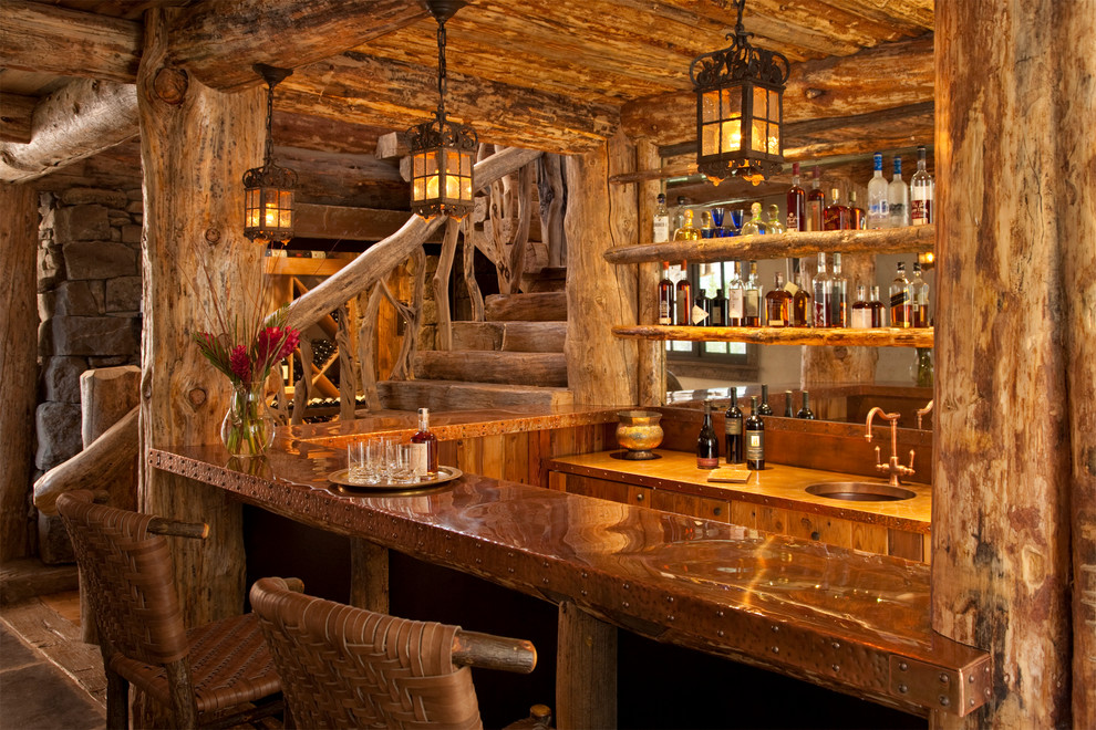 На фото: п-образный домашний бар в стиле рустика с барной стойкой, врезной мойкой, фасадами цвета дерева среднего тона и зеркальным фартуком с