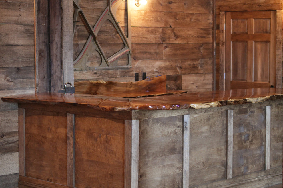Exemple d'un bar de salon montagne en U et bois brun de taille moyenne avec aucun évier ou lavabo, un placard sans porte, un plan de travail en bois, une crédence marron, une crédence en bois et un sol en bois brun.