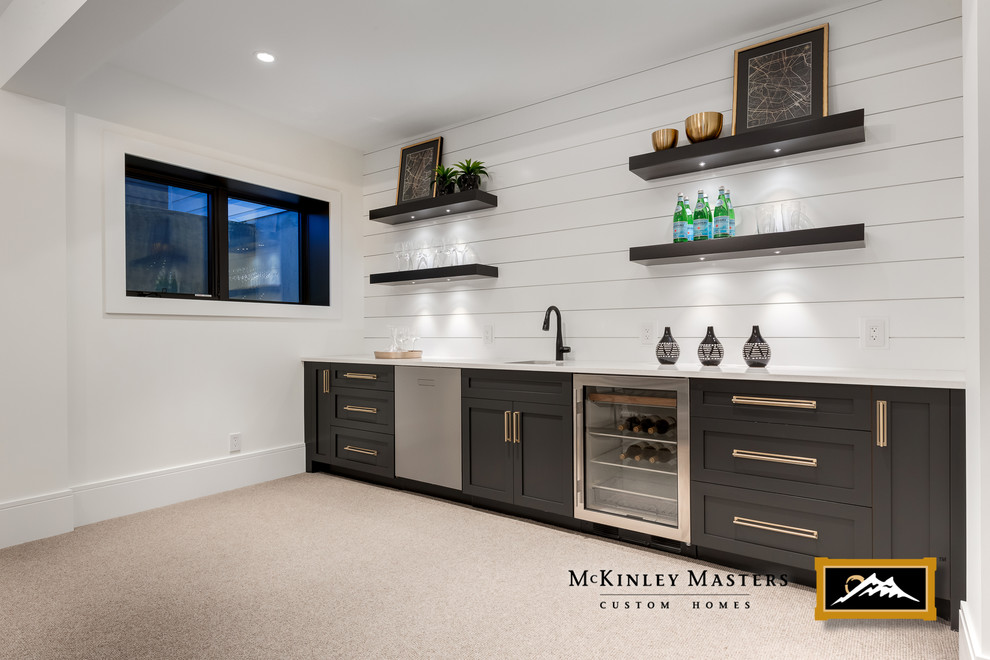 Photo of a large farmhouse single-wall wet bar in Calgary with a submerged sink, shaker cabinets, black cabinets, engineered stone countertops, carpet and white worktops.