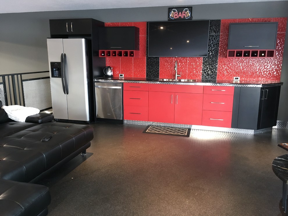 This is an example of an urban home bar in Calgary with a built-in sink, red cabinets, stainless steel worktops, red splashback, ceramic splashback and concrete flooring.
