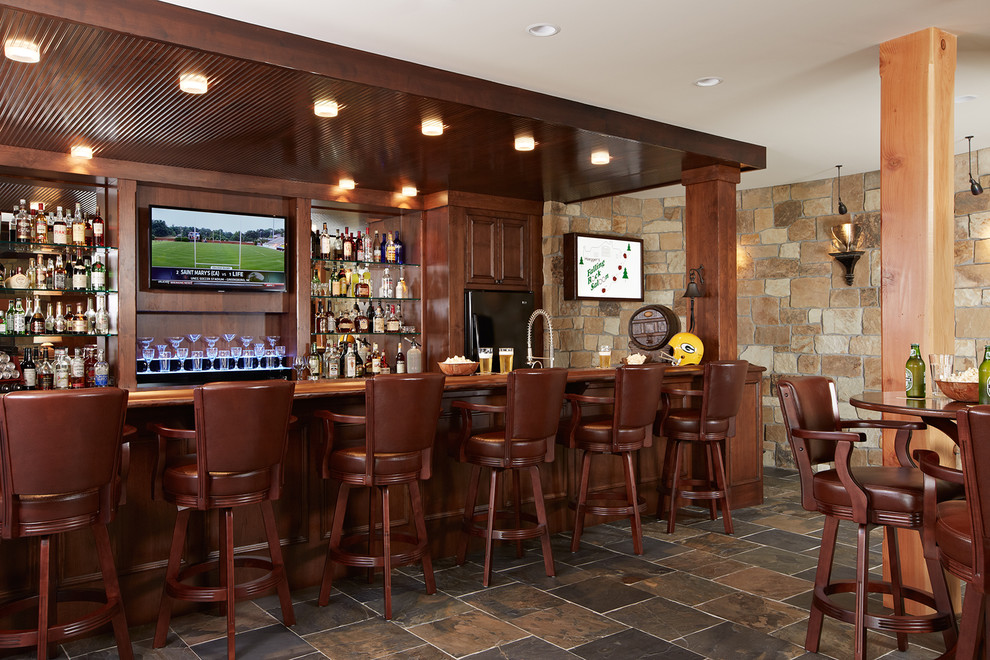 This is an example of a large traditional home bar in Minneapolis.