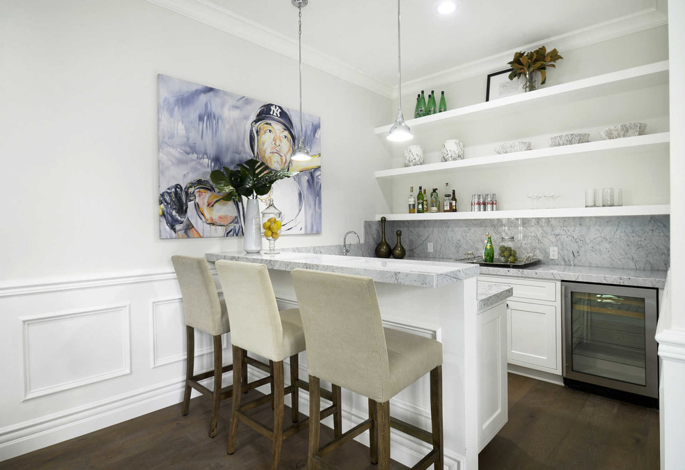 Modelo de bar en casa con barra de bar en U clásico renovado con armarios estilo shaker, puertas de armario blancas, suelo de madera oscura, suelo marrón y encimeras blancas