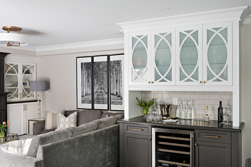 Example of a large transitional dark wood floor home bar design in Toronto with shaker cabinets, white cabinets, granite countertops, gray backsplash and subway tile backsplash