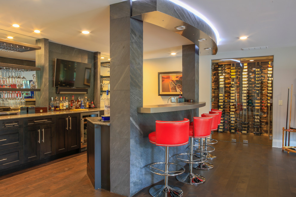 Esempio di un grande angolo bar con lavandino design con ante con riquadro incassato, ante in legno bruno, top in granito e pavimento in legno massello medio