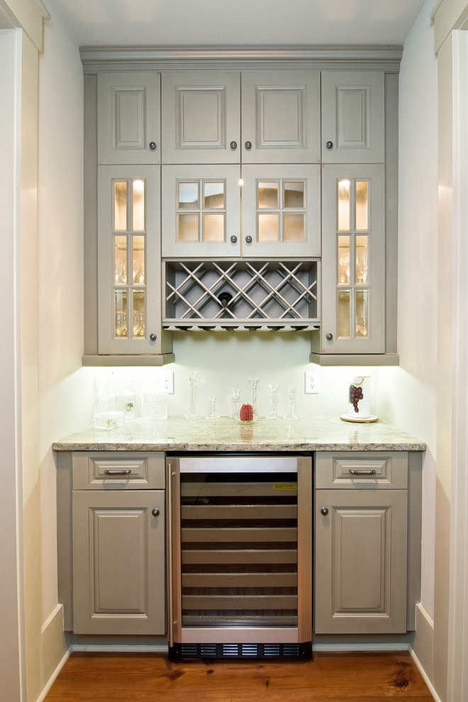 Inspiration for a small traditional single-wall home bar in San Diego with raised-panel cabinets, grey cabinets, granite worktops, dark hardwood flooring and brown floors.