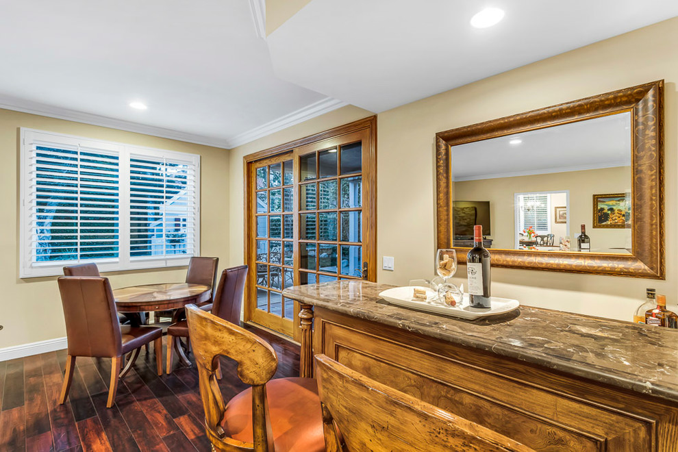 Cette photo montre un petit bar de salon parallèle chic en bois brun avec des tabourets, plan de travail en marbre, un sol en bois brun, un sol marron et un plan de travail marron.