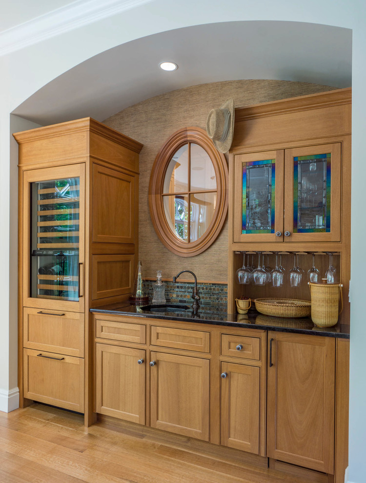 Inspiration for a classic single-wall wet bar in Boston with a submerged sink, beaded cabinets, medium wood cabinets, multi-coloured splashback, mosaic tiled splashback and medium hardwood flooring.