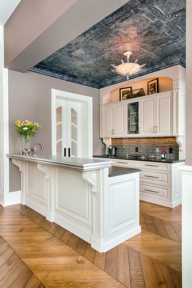 Inspiration for a traditional wet bar in Other with raised-panel cabinets, white cabinets and grey splashback.