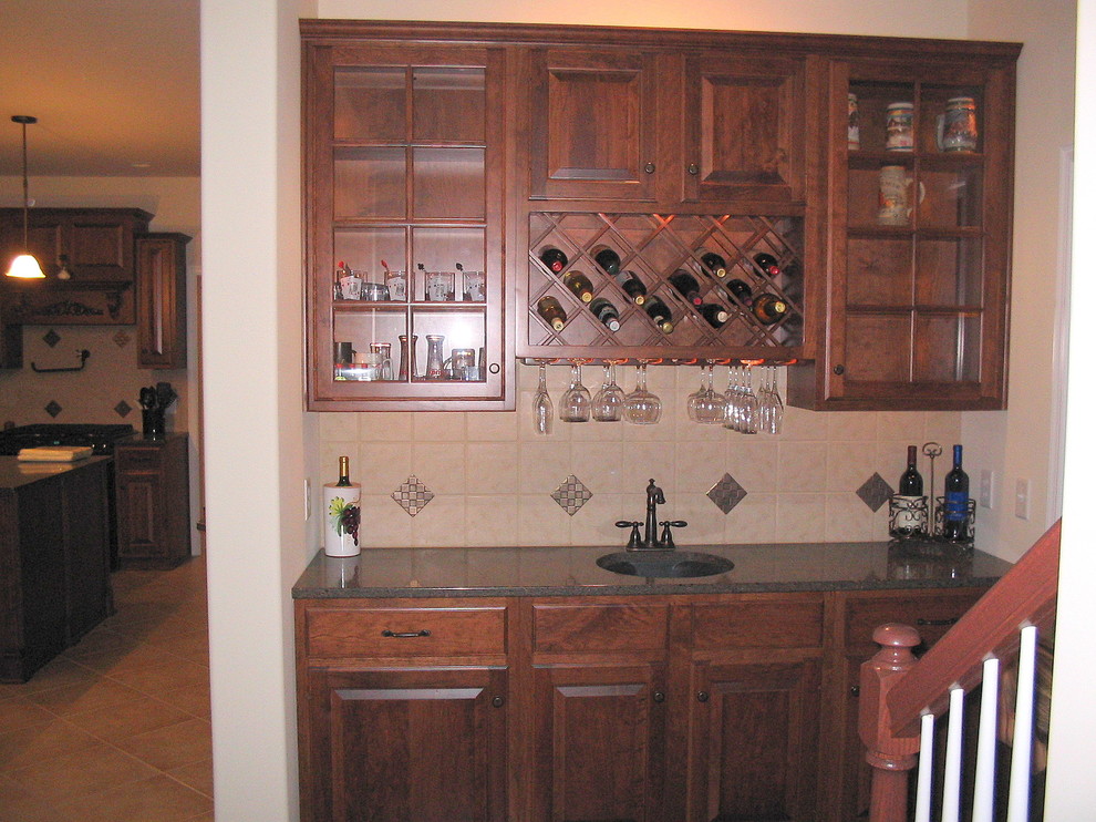 Example of a small classic single-wall ceramic tile wet bar design in Philadelphia with an undermount sink, raised-panel cabinets, medium tone wood cabinets, multicolored backsplash and ceramic backsplash