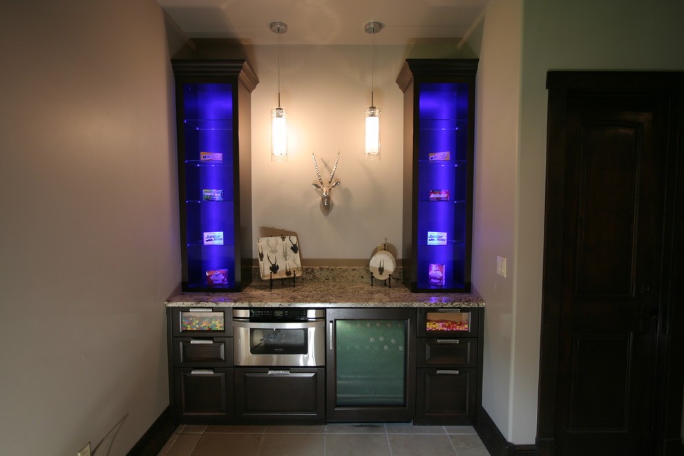 Example of a small transitional single-wall ceramic tile wet bar design in Denver with raised-panel cabinets, dark wood cabinets and granite countertops