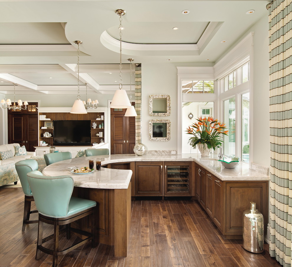 Large traditional u-shaped breakfast bar in Tampa with raised-panel cabinets, dark wood cabinets, dark hardwood flooring, a submerged sink, marble worktops, brown floors and white worktops.