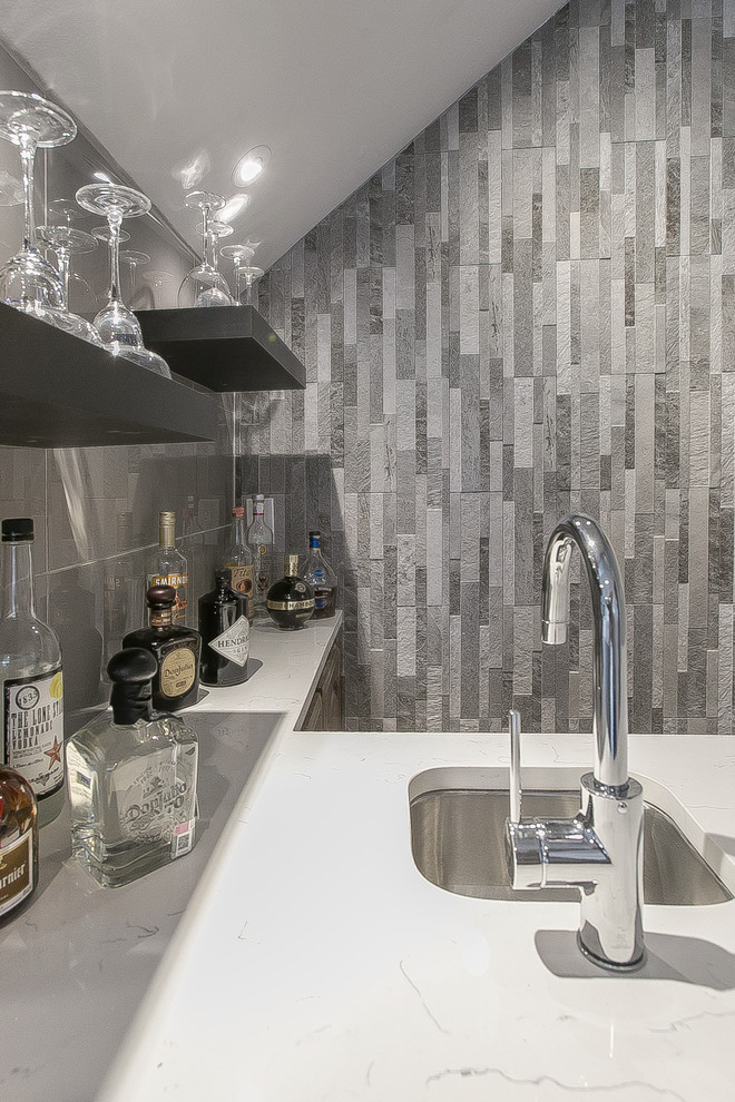 Example of a small trendy single-wall wet bar design in Dallas with an undermount sink, quartz countertops, gray backsplash, stone tile backsplash and white countertops