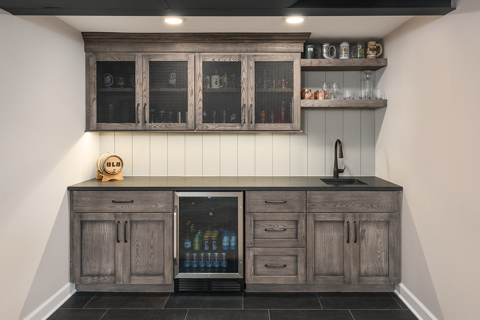 Inspiration for a mid-sized transitional single-wall black floor and slate floor wet bar remodel in Chicago with medium tone wood cabinets, white backsplash, wood backsplash, black countertops, an undermount sink, recessed-panel cabinets and soapstone countertops