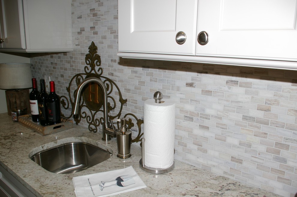Klassisk inredning av en liten linjär hemmabar med vask, med en undermonterad diskho, släta luckor, grå skåp, granitbänkskiva, grått stänkskydd, stänkskydd i mosaik och klinkergolv i porslin
