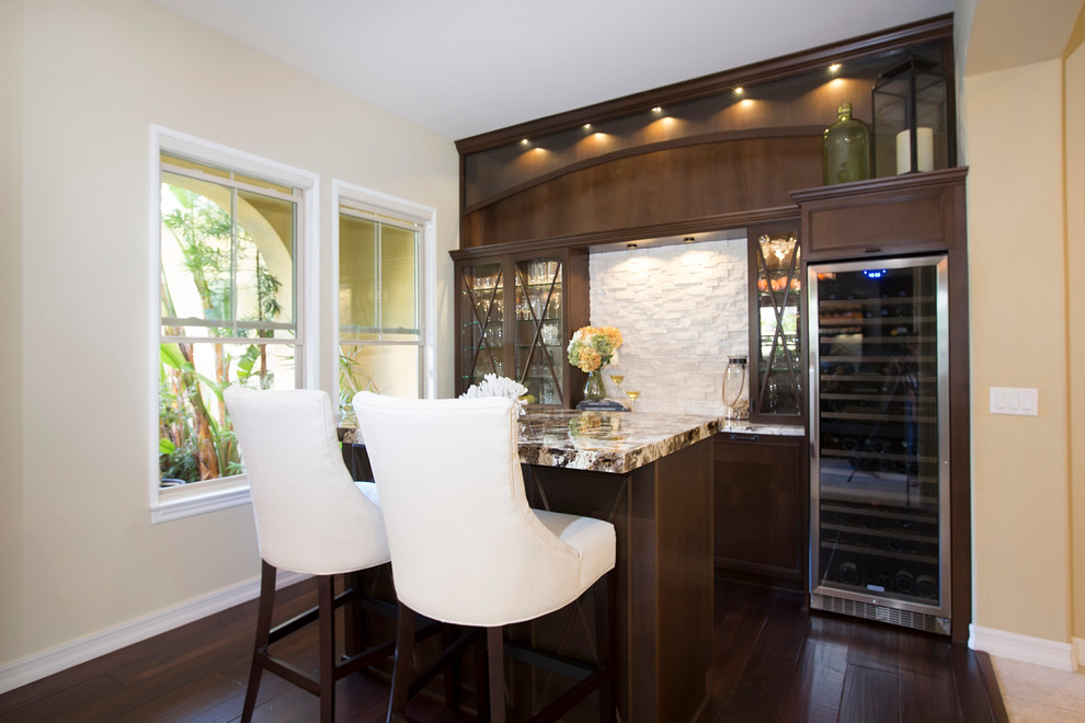 Inspiration for a mid-sized transitional single-wall dark wood floor seated home bar remodel in San Diego with raised-panel cabinets, dark wood cabinets, granite countertops, white backsplash and stone tile backsplash