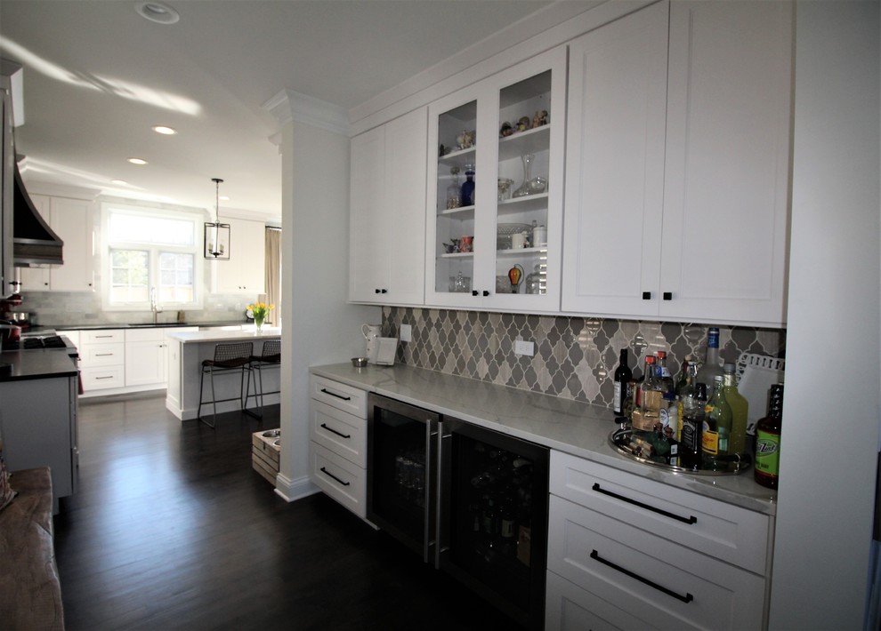 Exempel på en mellanstor klassisk grå linjär grått hemmabar med vask, med luckor med infälld panel, vita skåp, bänkskiva i kvarts, flerfärgad stänkskydd, stänkskydd i keramik, mörkt trägolv och svart golv