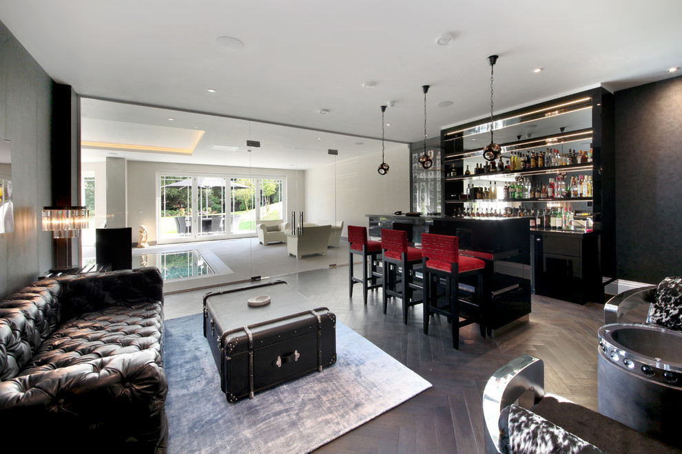 Moderne Hausbar mit Bartheke, offenen Schränken, Rückwand aus Spiegelfliesen und dunklem Holzboden in Surrey