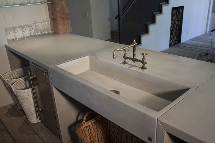 Esempio di un bancone bar chic di medie dimensioni con lavello integrato, top in cemento e pavimento in legno massello medio