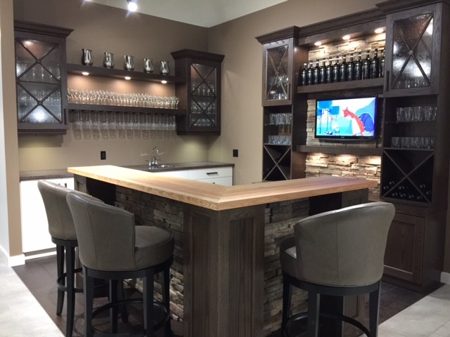 This is an example of a medium sized traditional l-shaped wet bar in Toronto with a built-in sink, shaker cabinets, dark wood cabinets, wood worktops and dark hardwood flooring.
