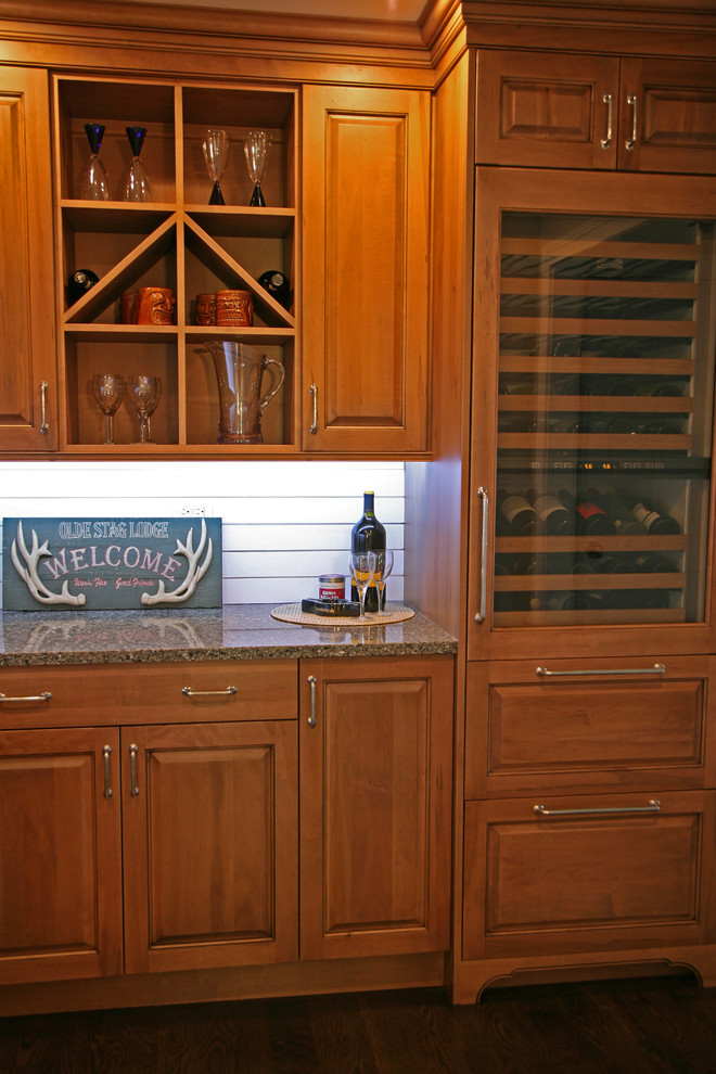 This is an example of a traditional home bar in Milwaukee with recessed-panel cabinets, white cabinets, dark hardwood flooring and white splashback.