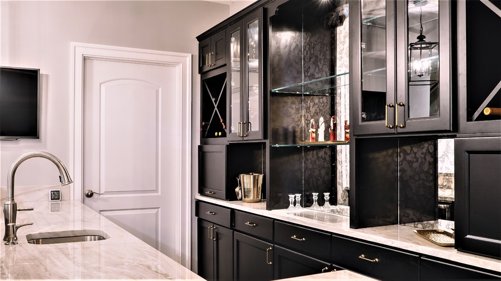 Esempio di un grande bancone bar classico con lavello sottopiano, ante nere, top in marmo, parquet scuro e paraspruzzi a specchio