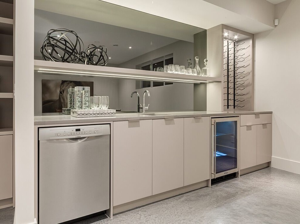 Idéer för en mellanstor modern linjär hemmabar med vask, med en undermonterad diskho, släta luckor, vita skåp, marmorbänkskiva, betonggolv och spegel som stänkskydd