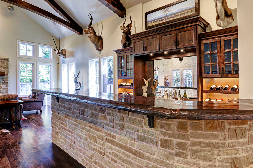 Aménagement d'un bar de salon classique en bois foncé avec des tabourets, un évier intégré, un placard à porte shaker, plan de travail en marbre, un sol en bois brun, un sol marron et un plan de travail multicolore.