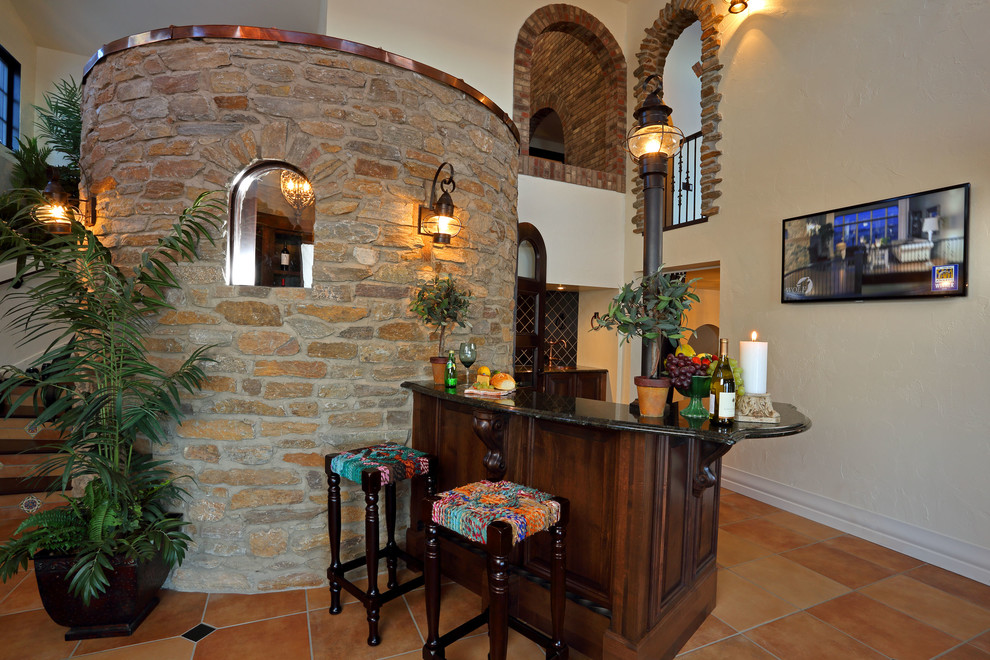 Стильный дизайн: домашний бар в средиземноморском стиле с полом из терракотовой плитки и темными деревянными фасадами - последний тренд