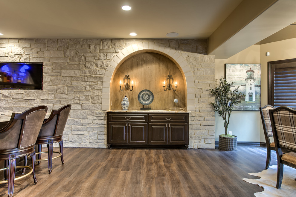 Inspiration for a timeless u-shaped seated home bar remodel in Omaha with an undermount sink, raised-panel cabinets, dark wood cabinets, onyx countertops and stone slab backsplash